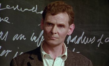 Movie still from “Wittgenstein” (1993), directed by Derek Jarman – A person wearing a jacket; Close Up shot, Low angle
