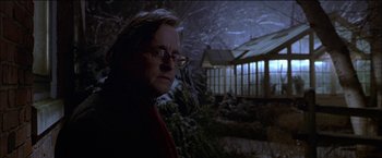 Movie still from “Wonder Boys” (2000), directed by Curtis Hanson – A man with glasses standing in front of a building; Close Up shot, Low angle