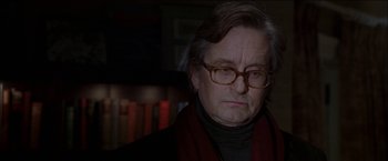 Movie still from “Wonder Boys” (2000), directed by Curtis Hanson – An older man wearing glasses and a red scarf; Close Up shot, Over the shoulder angle