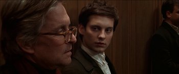 Movie still from “Wonder Boys” (2000), directed by Curtis Hanson – A man in a suit standing next to another man in a suit; Close Up shot, Over the shoulder angle