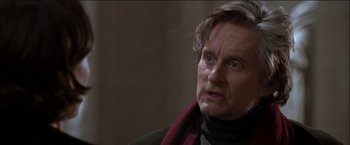 Movie still from “Wonder Boys” (2000), directed by Curtis Hanson – An older man wearing a scarf and a black jacket; Close Up shot, Over the shoulder angle