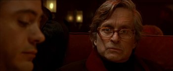 Movie still from “Wonder Boys” (2000), directed by Curtis Hanson – An older man wearing glasses sitting in a chair; Close Up shot, Over the shoulder angle