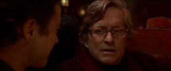 Movie still from “Wonder Boys” (2000), directed by Curtis Hanson – A person wearing glasses and a jacket; Close Up shot, Over the shoulder angle
