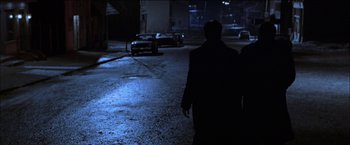 Movie still from “Wonder Boys” (2000), directed by Curtis Hanson – A man walking down a street at night; Wide shot, Over the shoulder angle