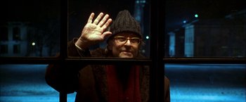 Movie still from “Wonder Boys” (2000), directed by Curtis Hanson – A man in a hat and glasses is looking out of a window; Close Up shot, Over the shoulder angle