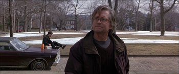 Movie still from “Wonder Boys” (2000), directed by Curtis Hanson – A man in a brown jacket is standing on the sidewalk; Medium shot, Over the shoulder angle
