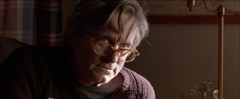Movie still from “Wonder Boys” (2000), directed by Curtis Hanson – An older man wearing glasses and wearing a sweater; Close Up shot, Over the shoulder angle
