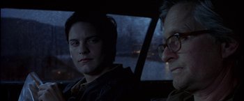 Movie still from “Wonder Boys” (2000), directed by Curtis Hanson – A man sitting in the back of a car next to another man; Close Up shot, Over the shoulder angle