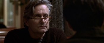 Movie still from “Wonder Boys” (2000), directed by Curtis Hanson – An older man wearing glasses and a brown sweater; Close Up shot, Over the shoulder angle