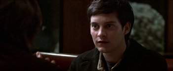 Movie still from “Wonder Boys” (2000), directed by Curtis Hanson – A young man with short brown hair wearing a brown jacket; Close Up shot, Over the shoulder angle