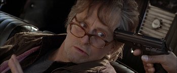 Movie still from “Wonder Boys” (2000), directed by Curtis Hanson – An older man wearing glasses and a brown jacket; Close Up shot, Over the shoulder angle