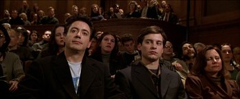 Movie still from “Wonder Boys” (2000), directed by Curtis Hanson – A group of people sitting in front of an audience; Medium shot, High angle