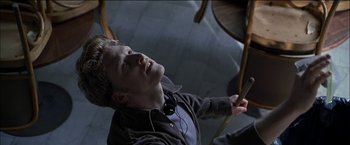 Movie still from “Wonder Boys” (2000), directed by Curtis Hanson – A man with headphones is holding a drum; Medium shot, Overhead angle