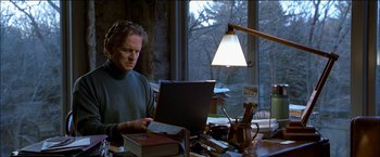 Movie still from “Wonder Boys” (2000), directed by Curtis Hanson – A man sitting in front of a laptop computer on top of a desk; Medium shot, Low angle