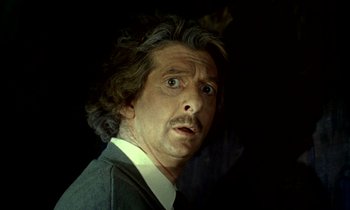 Movie still from “Wonderwall” (1968), directed by Joe Massot – A person wearing a suit and tie; Close Up shot, Low angle