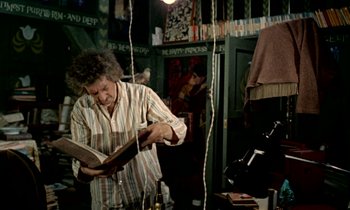 An older man reading a book in a room