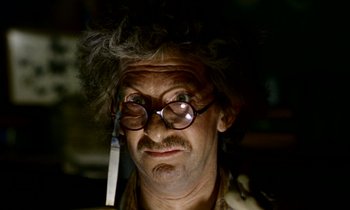 Movie still from “Wonderwall” (1968), directed by Joe Massot – An old man wearing glasses with a knife in his hand; Close Up shot, Low angle