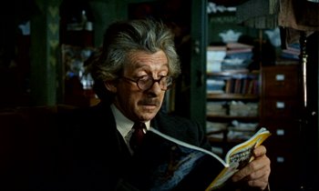 Movie still from “Wonderwall” (1968), directed by Joe Massot – An older man wearing a suit and reading a book; Close Up shot, Low angle