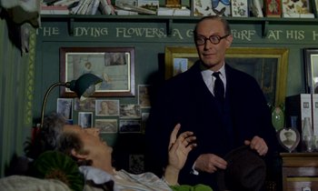 Movie still from “Wonderwall” (1968), directed by Joe Massot – A man in a suit talking to another man in a suit; Medium shot, Over the shoulder angle