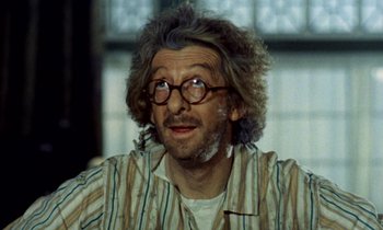 Movie still from “Wonderwall” (1968), directed by Joe Massot – An older man wearing glasses and a striped shirt; Close Up shot, Low angle