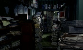 Movie still from “Wonderwall” (1968), directed by Joe Massot – A room filled with lots of books and papers; Wide shot, High angle