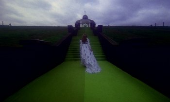 Movie still from “Wonderwall” (1968), directed by Joe Massot – A woman in a white dress is walking down a set of stairs; Wide shot, High angle