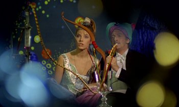 Movie still from “Wonderwall” (1968), directed by Joe Massot – A man and a woman sitting at a table with a glass of wine; Medium shot, High angle