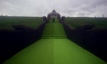 Movie still from “Wonderwall” (1968), directed by Joe Massot – A person walking down a set of stairs; Extreme Wide shot, High angle