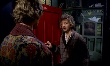 Movie still from “Wonderwall” (1968), directed by Joe Massot – Two men are talking in front of a red door; Medium shot, Over the shoulder angle