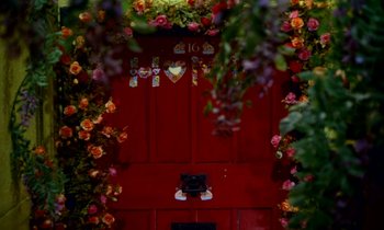 Movie still from “Wonderwall” (1968), directed by Joe Massot – A red door surrounded by colorful flowers and vines; Extreme Close Up shot, Low angle