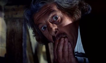 Movie still from “Wonderwall” (1968), directed by Joe Massot – An older man with long grey hair is holding his hands to his face; Close Up shot, Low angle