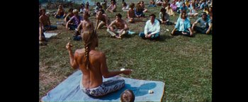 Movie still from “Woodstock” (1970), directed by Michael Wadleigh – A group of people sitting in the grass; Wide shot, High angle