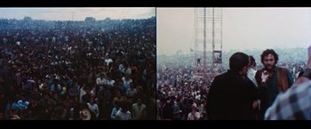 Movie still from “Woodstock” (1970), directed by Michael Wadleigh – A crowd of people sitting in front of an audience; Extreme Wide shot, High angle