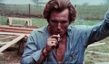 Movie still from “Woodstock” (1970), directed by Michael Wadleigh – A person smoking a cigarette; Close Up shot, Low angle