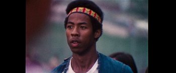Movie still from “Woodstock” (1970), directed by Michael Wadleigh – A person wearing a headband; Close Up shot, Low angle