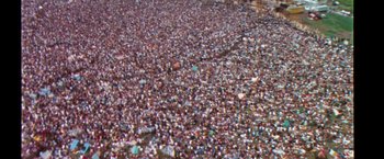 Movie still from “Woodstock” (1970), directed by Michael Wadleigh – An aerial view of a large crowd of people; Extreme Wide shot, High angle