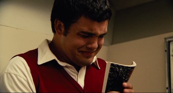 Movie still from “World's Greatest Dad” (2009), directed by Bobcat Goldthwait – A man in a red vest is holding a book; Close Up shot, Low angle
