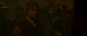 Movie still from “Wyatt Earp” (1994), directed by Lawrence Kasdan – A woman in a black dress and a man in a black hat; Medium shot, Over the shoulder angle