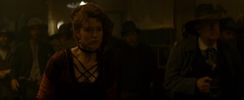 Movie still from “Wyatt Earp” (1994), directed by Lawrence Kasdan – A woman in a black dress and a black hat; Medium shot, Over the shoulder angle