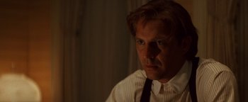 Movie still from “Wyatt Earp” (1994), directed by Lawrence Kasdan – A person wearing a shirt and tie; Close Up shot, Over the shoulder angle