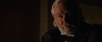 Movie still from “Wyatt Earp” (1994), directed by Lawrence Kasdan – An old man with a white beard is looking at the camera; Close Up shot, Low angle