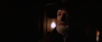 Movie still from “Wyatt Earp” (1994), directed by Lawrence Kasdan – An old man with a beard wearing a cowboy hat; Close Up shot, Over the shoulder angle