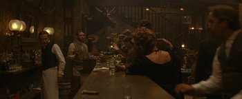 Movie still from “Wyatt Earp” (1994), directed by Lawrence Kasdan – A group of people sitting at a long table; Wide shot, Low angle