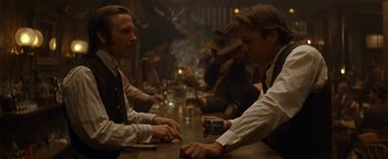 Movie still from “Wyatt Earp” (1994), directed by Lawrence Kasdan – A group of people sitting at a bar; Medium shot, Over the shoulder angle