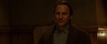 Movie still from “Wyatt Earp” (1994), directed by Lawrence Kasdan – A person wearing a jacket and smiling; Close Up shot, Over the shoulder angle