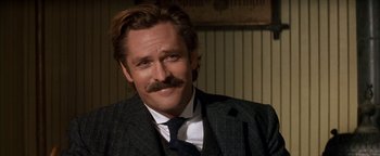 Movie still from “Wyatt Earp” (1994), directed by Lawrence Kasdan – A person wearing a suit and tie; Close Up shot, Low angle