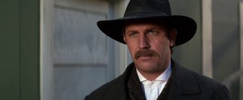 Movie still from “Wyatt Earp” (1994), directed by Lawrence Kasdan – A person wearing a suit and hat; Close Up shot, Low angle