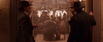 Movie still from “Wyatt Earp” (1994), directed by Lawrence Kasdan – A group of people sitting around a table; Wide shot, Low angle