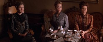 Movie still from “Wyatt Earp” (1994), directed by Lawrence Kasdan – A woman sitting at a table with a tea set; Medium shot, High angle