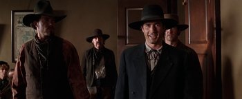 Movie still from “Wyatt Earp” (1994), directed by Lawrence Kasdan – A group of men wearing hats and suits; Medium shot, Low angle